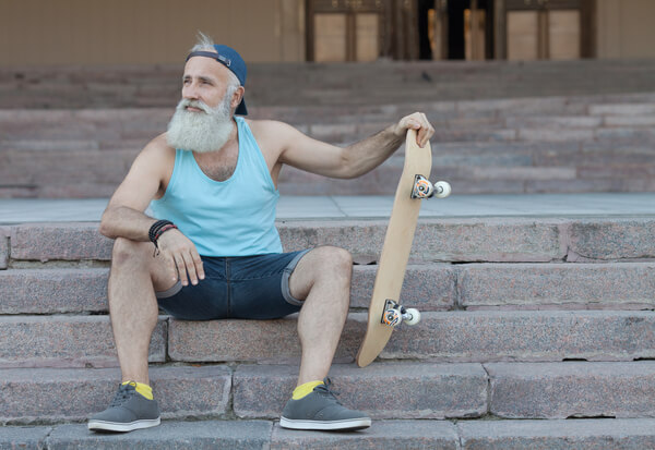 An old man holding a skateboard