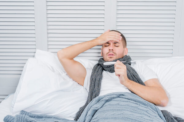 A man in bed feeling sick